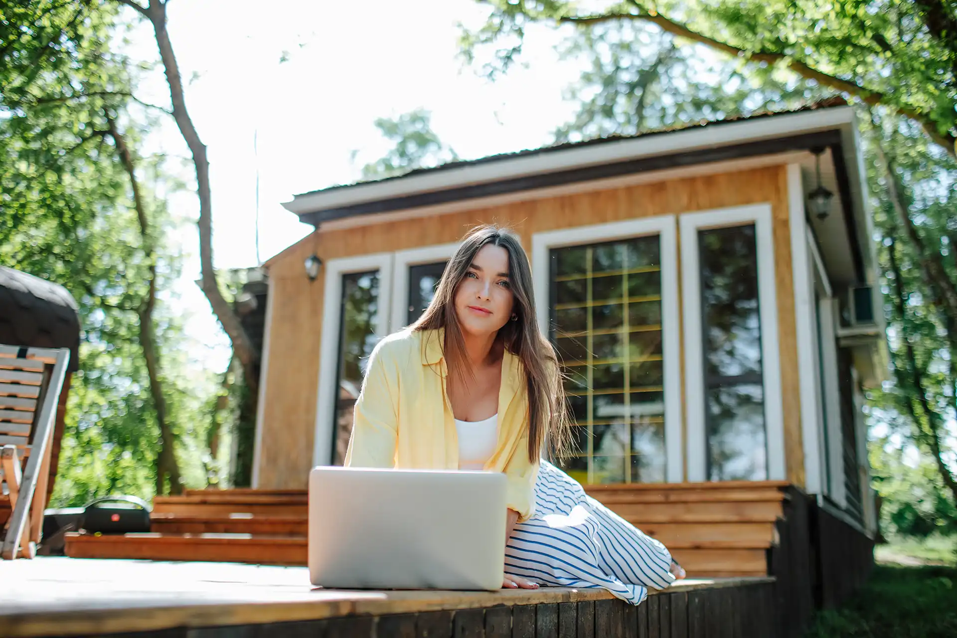 Arbeiten mit Laptop im Garten vor einem Gartenhaus