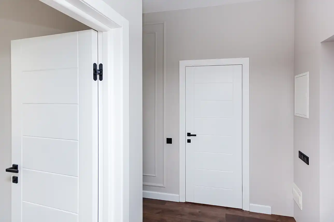 Mehrere weiße Innentüren mit schwarzen Türgriffen im Wohnraum