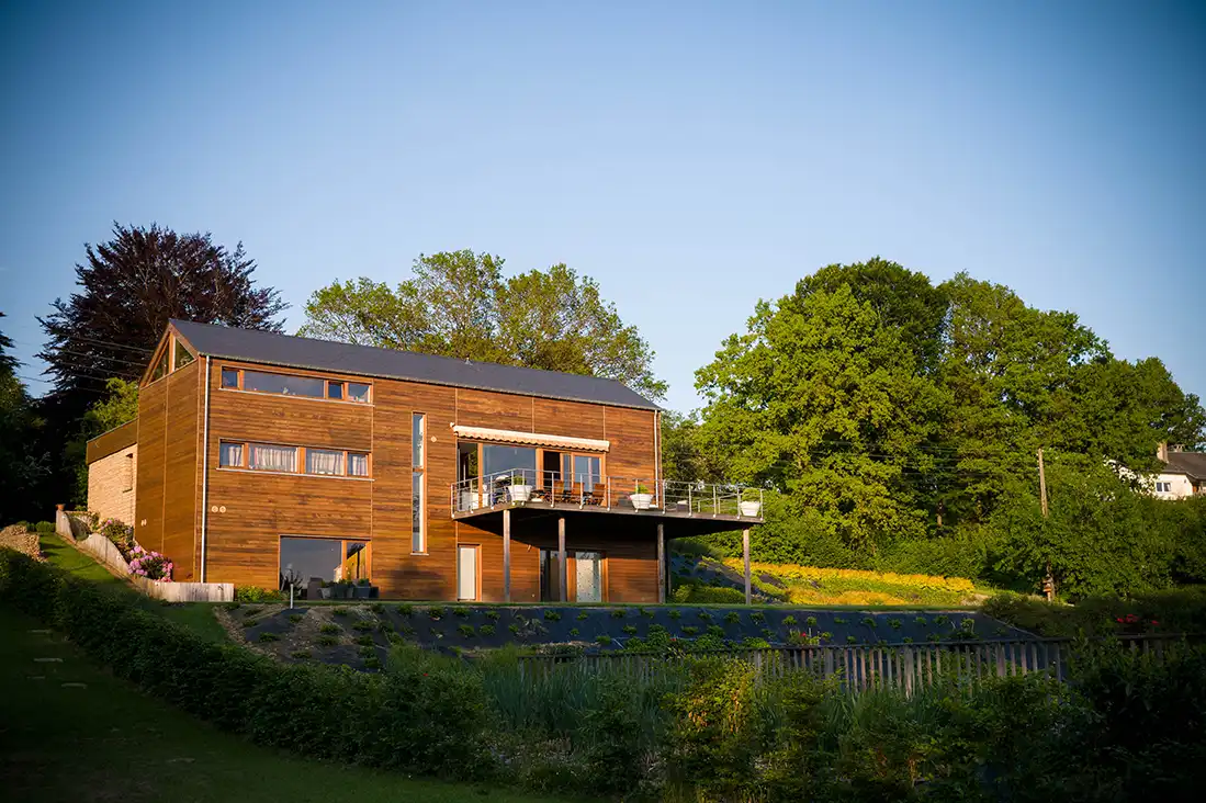 Modernes Wohnhaus mit Holzfassade, Terrasse und großen Fensterflächen
