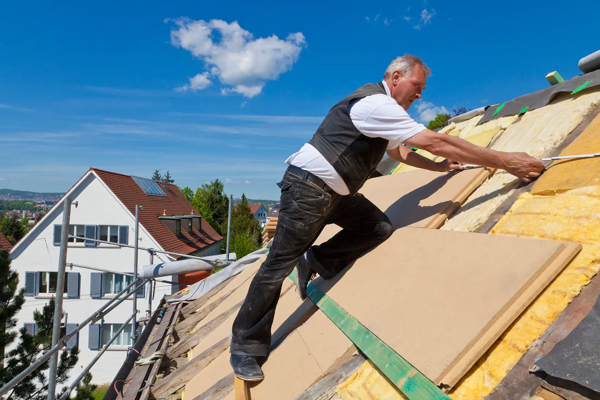 Handwerker verlegt Dämmplatten auf dem Dach zur Wärmedämmung
