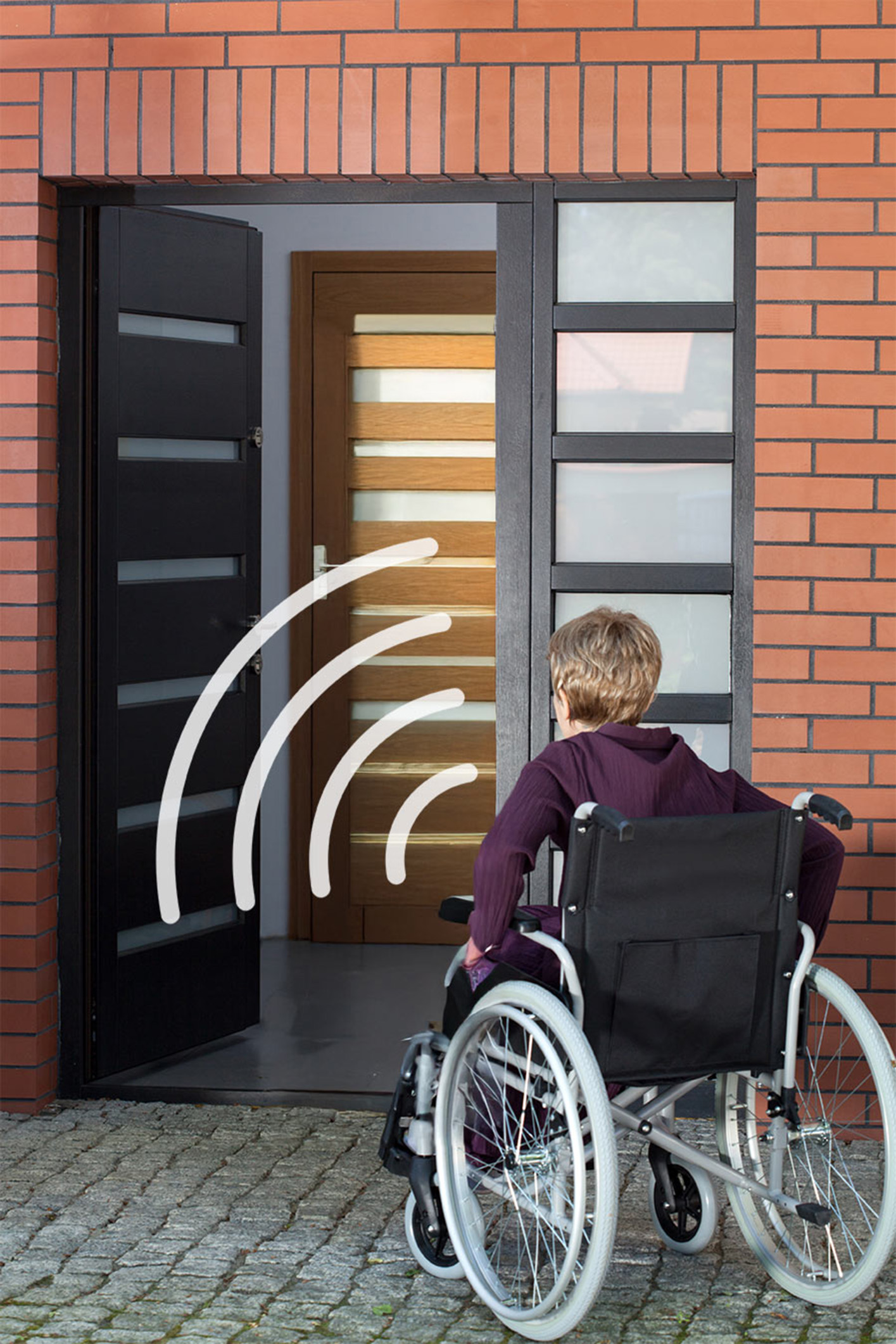 Barrierefreier Hauseingang mit Funktür Frau im Rollstuhl vor einer modernen Eingangstür mit Funktastensystem. Symbolische Funkwellen visualisieren die Türsteuerung